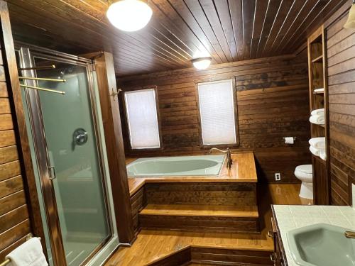 a bathroom with a tub and a shower and a toilet at Faithful Street Inn in West Yellowstone