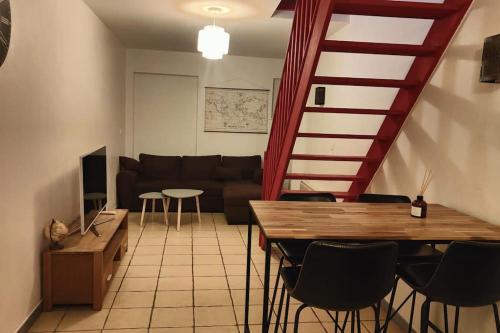 ein Wohnzimmer mit einem Sofa, einem Tisch und Stühlen in der Unterkunft Charmante maison de ville in Bolbec