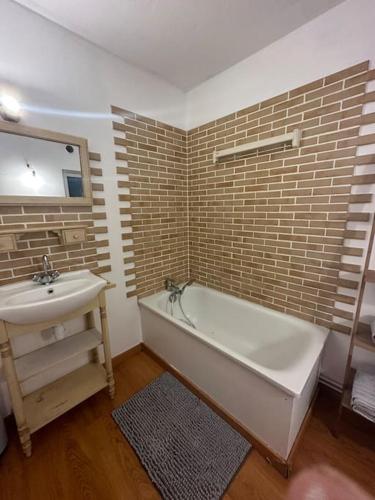 une salle de bain avec une baignoire blanche et un lavabo dans l'établissement Charmante maison de ville, à Bolbec