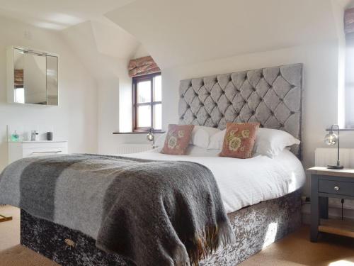 a bedroom with a large bed with a large headboard at Green Lane Cottage in Newtown