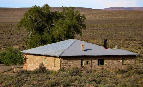 an old brick house with a tin roof on a field at Oupoort Eco & Guest Farm - Sutherland - Middelpos in Sutherland