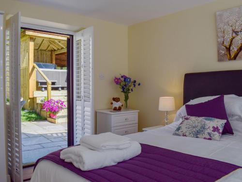 a bedroom with a bed and a door to a patio at The Coach House in Wootton Bridge