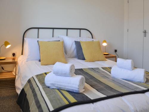 a bedroom with a bed with towels on it at Avocet Cottage in Sheringham