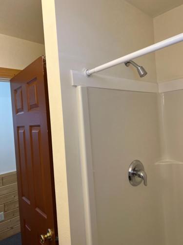 a shower in a bathroom with a door at Faithful Street Inn in West Yellowstone