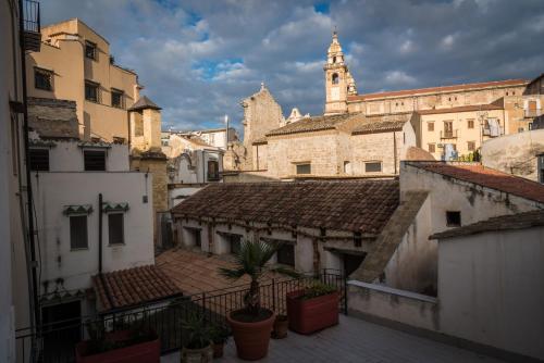 Blick auf eine Altstadt mit einem Uhrturm in der Unterkunft Alla Loggia Del Gattopardo in Palermo