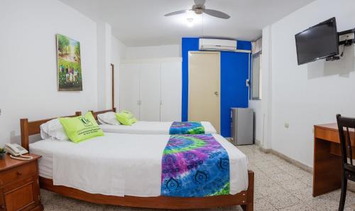 1 dormitorio con 1 cama, escritorio y TV en Hotel Country Boutique, en Piura