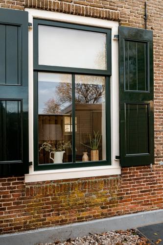 a window on the side of a brick building at Landelijk gelegen vakantiewoning in Oldebroek