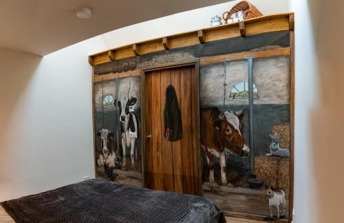 1 dormitorio con un mural de vacas en la pared en Landelijk gelegen vakantiewoning, en Oldebroek