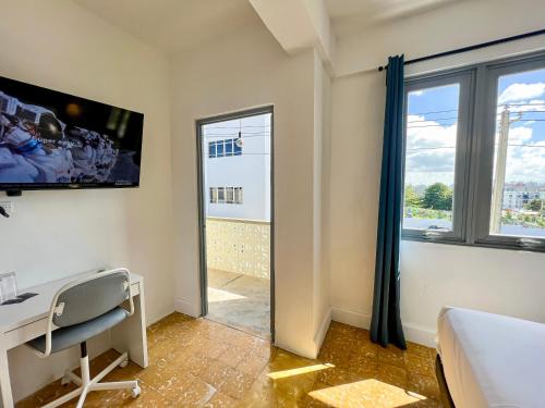 - une chambre avec un bureau et une fenêtre dans l'établissement Urbana Hotel, à San Juan