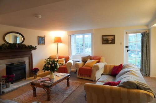 The Snicket - Traditional Cotswold Home في تشلتنهام: غرفة معيشة مع أريكة ومدفأة