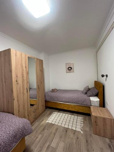 a bedroom with two beds and a mirror at ALFA Apartmani in Subotica