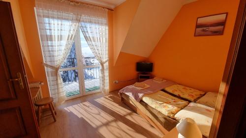 a small bedroom with a bed and a window at Willa u Skrajnioka in Czerwienne