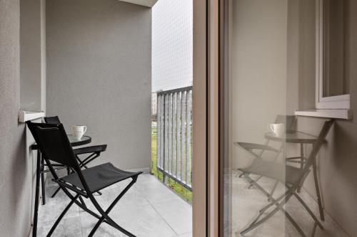 um quarto com uma varanda com cadeiras e uma mesa em Republiki Korczakowskiej Apartamenty em Cracóvia