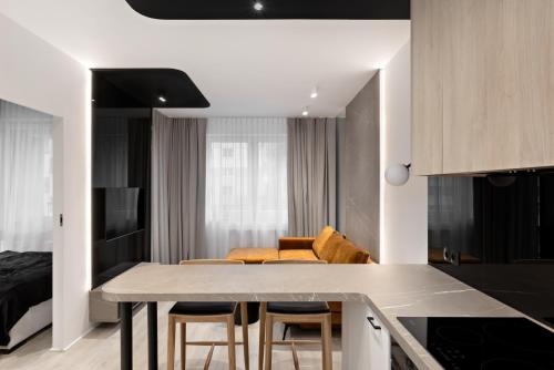 une cuisine et un salon avec une table et des chaises dans l'établissement Republiki Korczakowskiej Apartamenty, à Cracovie