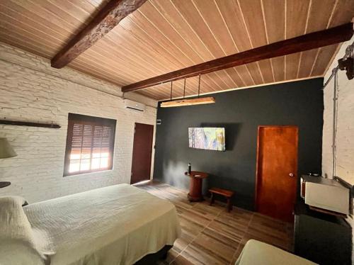 1 dormitorio con cama y techo de madera en LA POSADA en Aiguá