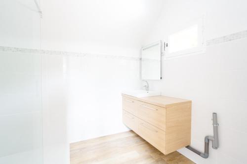 a bathroom with a wooden vanity and a mirror at Le Moulin de Dannemarie in Dannemarie