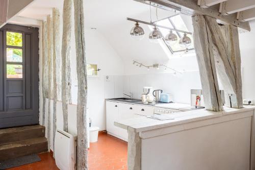a kitchen with white cabinets and a counter top at Le Moulin de Dannemarie in Dannemarie
