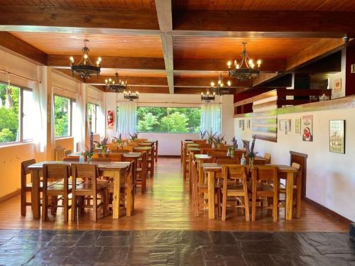 a dining room with wooden tables and chairs at Hosteria de la Villa - Moonski in San Carlos de Bariloche