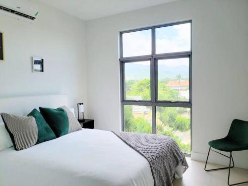 a white bedroom with a bed and a window at Infinity Pool Paradise Vacation Home in Kingston