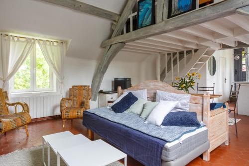 een slaapkamer met een bed met blauwe en witte kussens bij Le Moulin de Dannemarie in Dannemarie