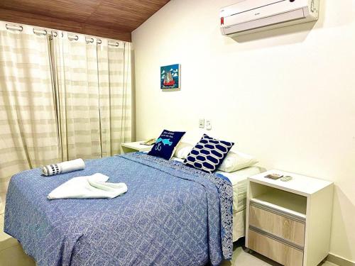 a bedroom with two beds with blue and white sheets at Solar Água Duplex Top in Pipa