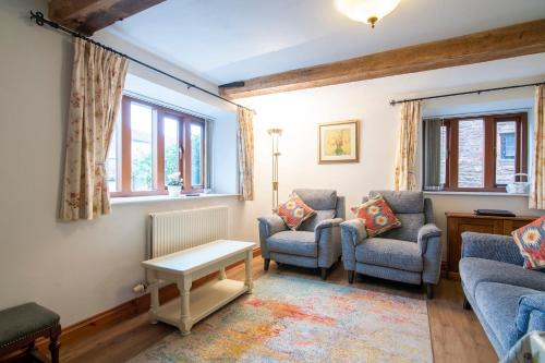 a living room with two chairs and a table at The Chaff House - farm stay apartment set within 135 acres in Bromyard