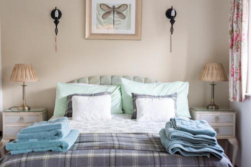 a bedroom with a bed with blue blankets and pillows at The Chaff House - farm stay apartment set within 135 acres in Bromyard