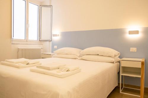 a bedroom with a white bed with two towels on it at Noliday Riviera Sea View Luxury Apartment in Noli