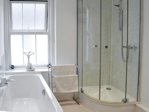 uma casa de banho com um chuveiro e uma banheira em Seaglass em Marazion