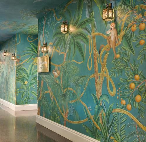 a mural of the jungle with monkeys on a wall at The Colony Hotel in Palm Beach