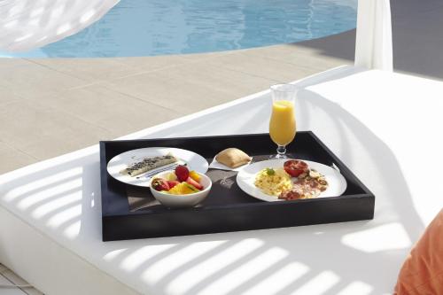 a tray with two plates of food and a glass of orange juice at Ibiza Sun Apartments in Playa d'en Bossa