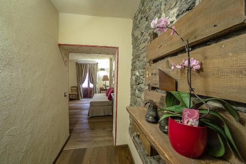 a room with a red vase with a flower in it at Domus Antica Aosta in Aosta
