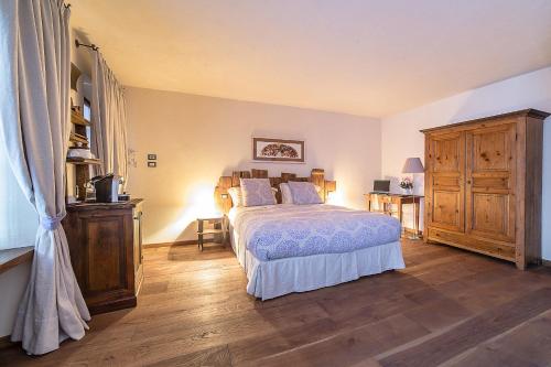 um quarto com uma cama e piso em madeira em Domus Antica Aosta em Aosta