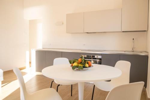 a white kitchen with a white table and chairs at Noliday Riviera Sea View Luxury Apartment in Noli