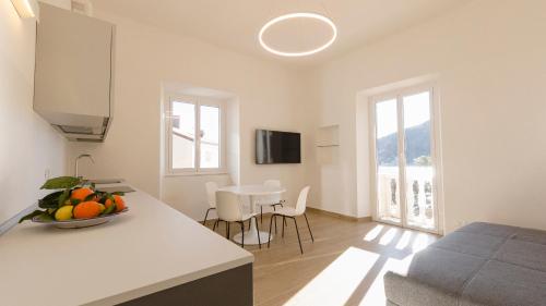 a kitchen and living room with a bowl of fruit on a counter at Noliday Riviera Sea View Luxury Apartment in Noli