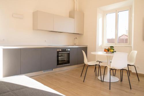 een keuken met een tafel en stoelen in een kamer bij Noliday Riviera Sea View Luxury Apartment in Noli