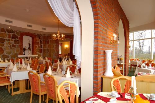 a restaurant with tables and chairs and a brick wall at Schloss Herrenstein in Gerswalde