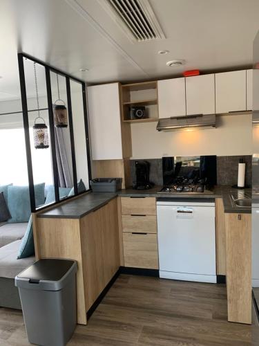 een keuken met witte kasten en een aanrechtblad bij Oostkapelle Chalet JD 56 In de Bongerd in Oostkapelle