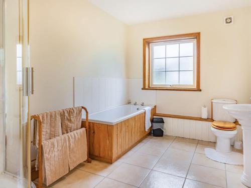 a bathroom with a tub and a toilet and a sink at Leedale Cottage in Saltmarshe