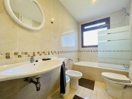 a bathroom with a sink and a toilet and a mirror at Villa loralil by costabravaway in Calonge