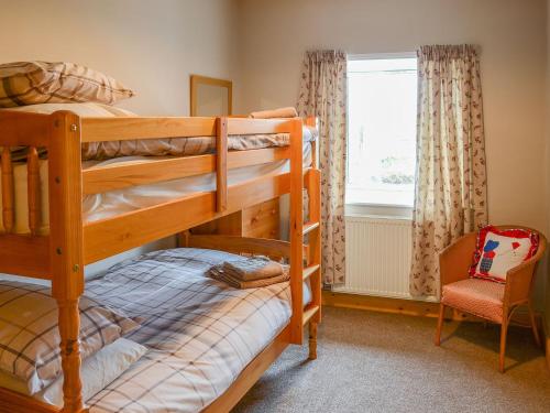 a bedroom with two bunk beds and a window at Sheaf Dale in Portmahomack