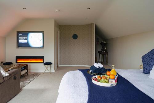 ein Hotelzimmer mit einem Bett und einem Tablett mit Obst darauf in der Unterkunft The Cosy Inn - Luxury Private Hot-Tub in Dungiven