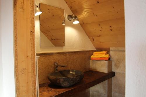 W łazience znajduje się kamienna umywalka i lustro. w obiekcie Die Mirnockhütte w mieście Ferndorf