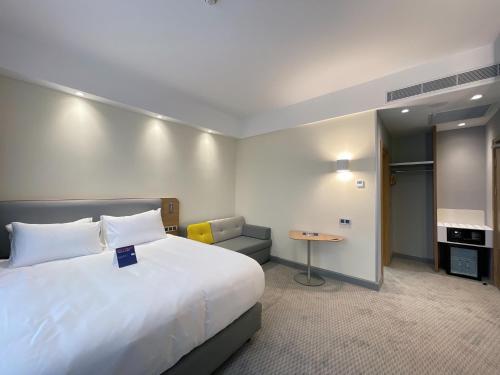 a hotel room with a large bed and a table at Holiday Inn Express - Ankara - Airport by IHG in Ankara