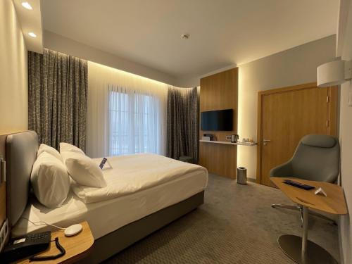 a hotel room with a bed and a desk and a television at Holiday Inn Express - Ankara - Airport by IHG in Ankara