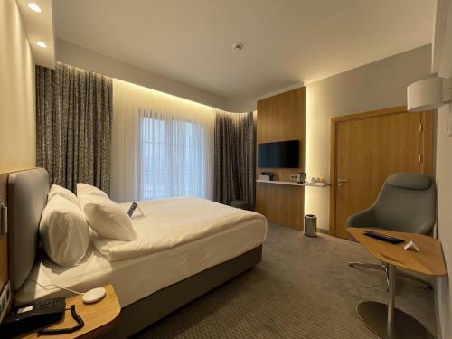 um quarto de hotel com uma cama, uma secretária e uma televisão em Holiday Inn Express - Ankara - Airport, an IHG Hotel em Ancara