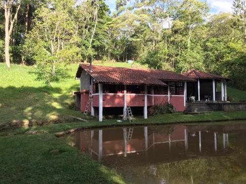 a small house next to a body of water at Chalé 4x4 alto da serra de Sao Roque. in São Roque