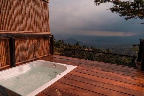 a hot tub on a wooden deck with a view at Romero Glamping y Cabañas in Cali