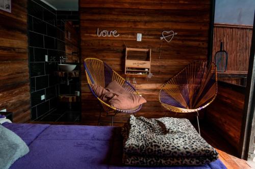 a bedroom with two wicker chairs and a bed at Romero Glamping y Cabañas in Cali