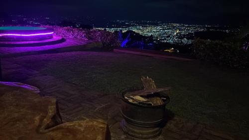 a view of a city at night with purple lights at Romero Glamping y Cabañas in Cali